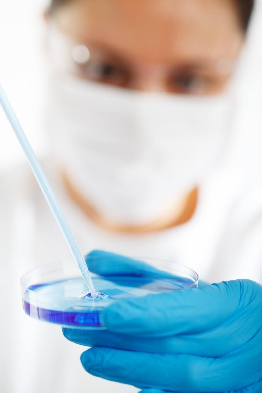 Doctor holding petri dish and pipette